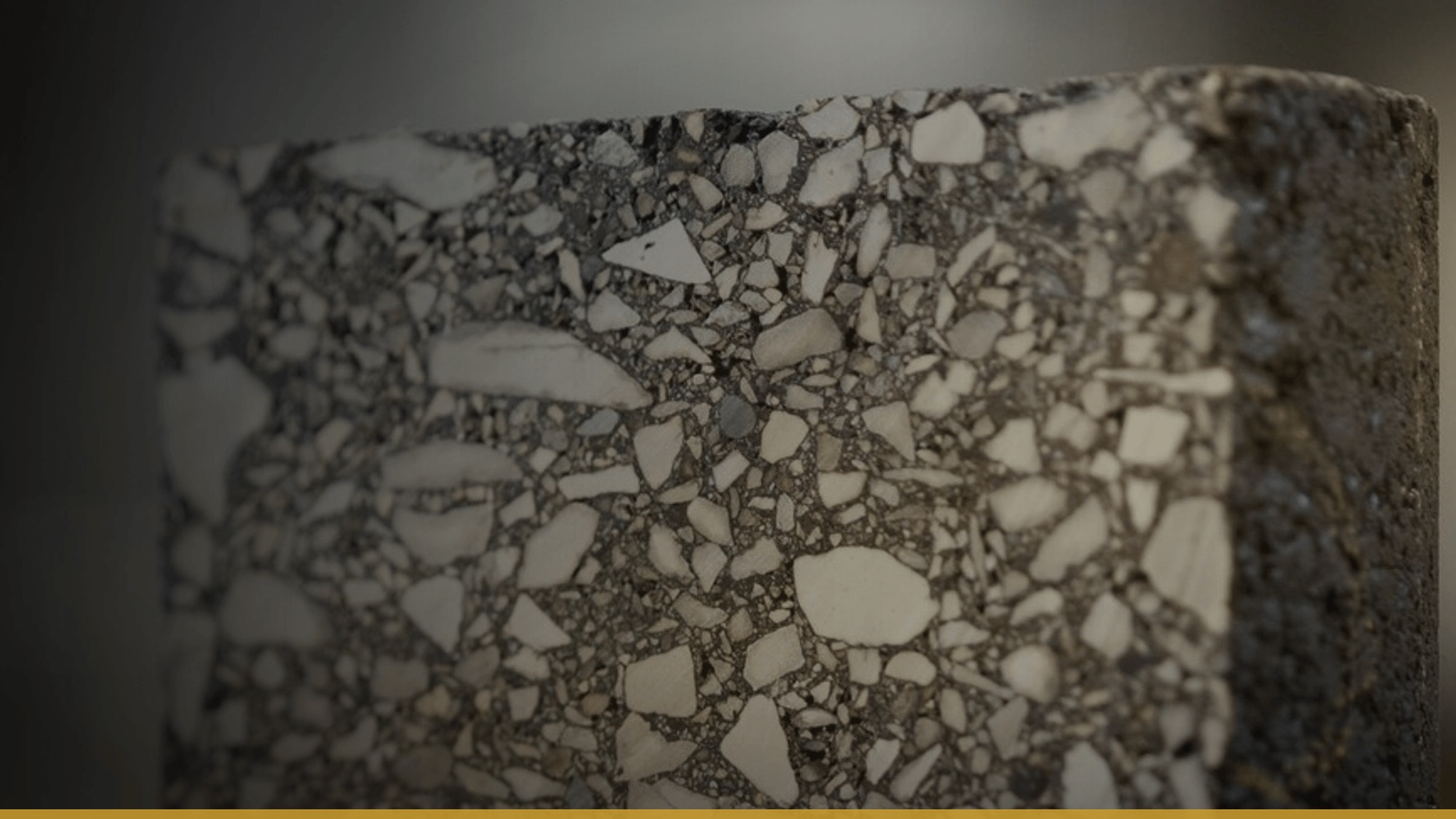 Close detail of asphalt aggregate and binder — the raw material whose behaviour every lab in the loop is measuring.